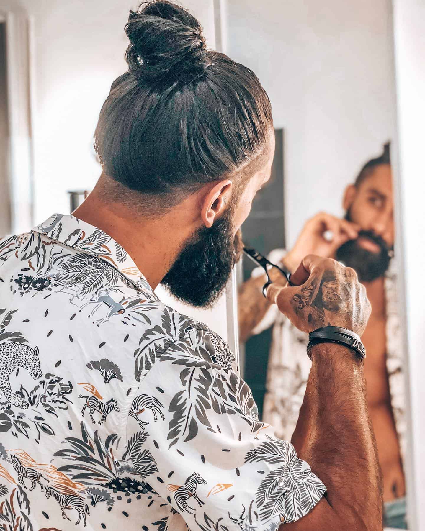 man trimming his mustache in-front of the mirror