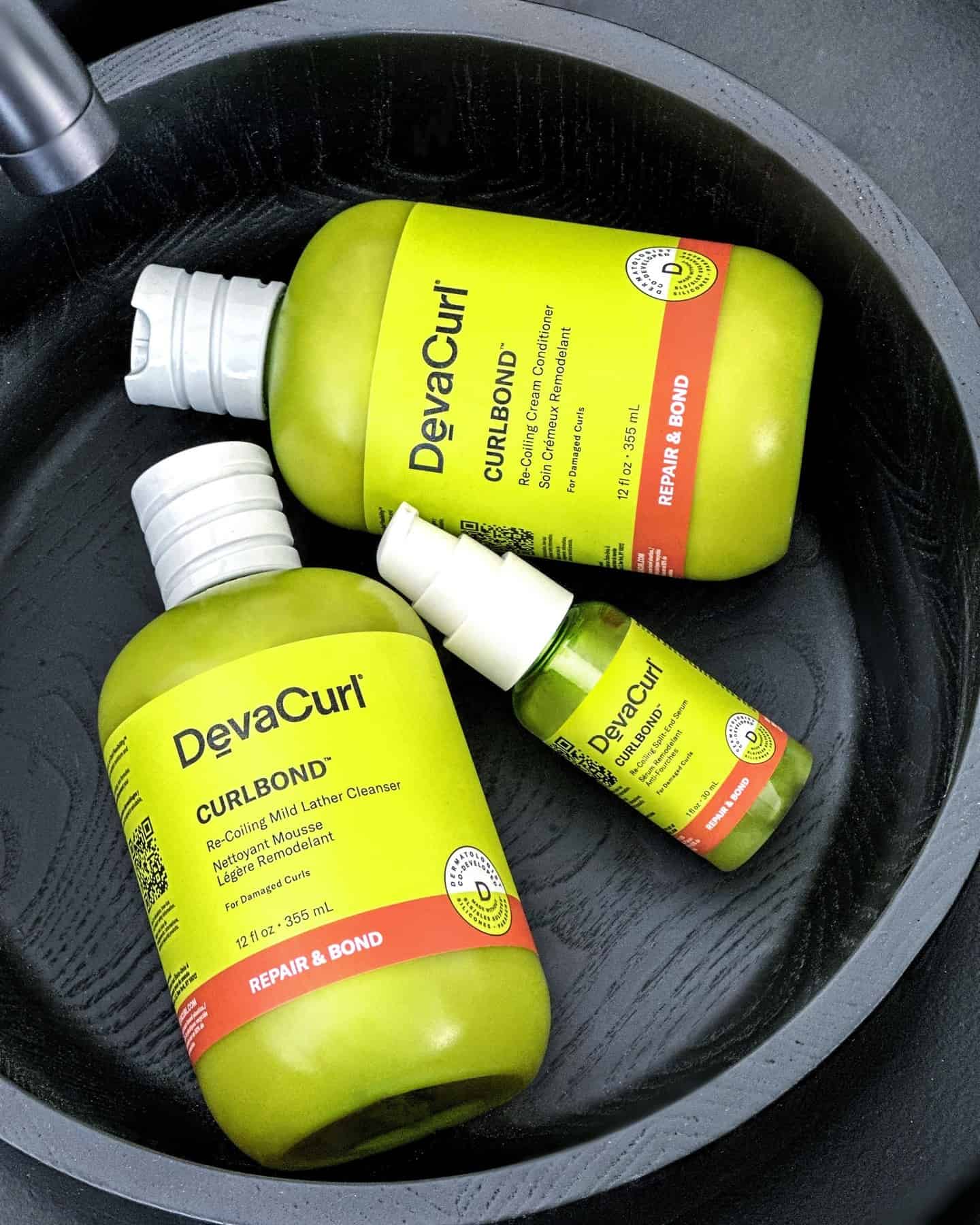 bottles of devacurl curlbond in a wooden bowl