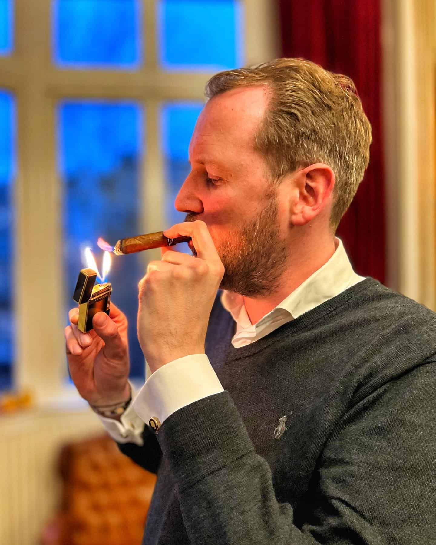 man lighting up a cigar