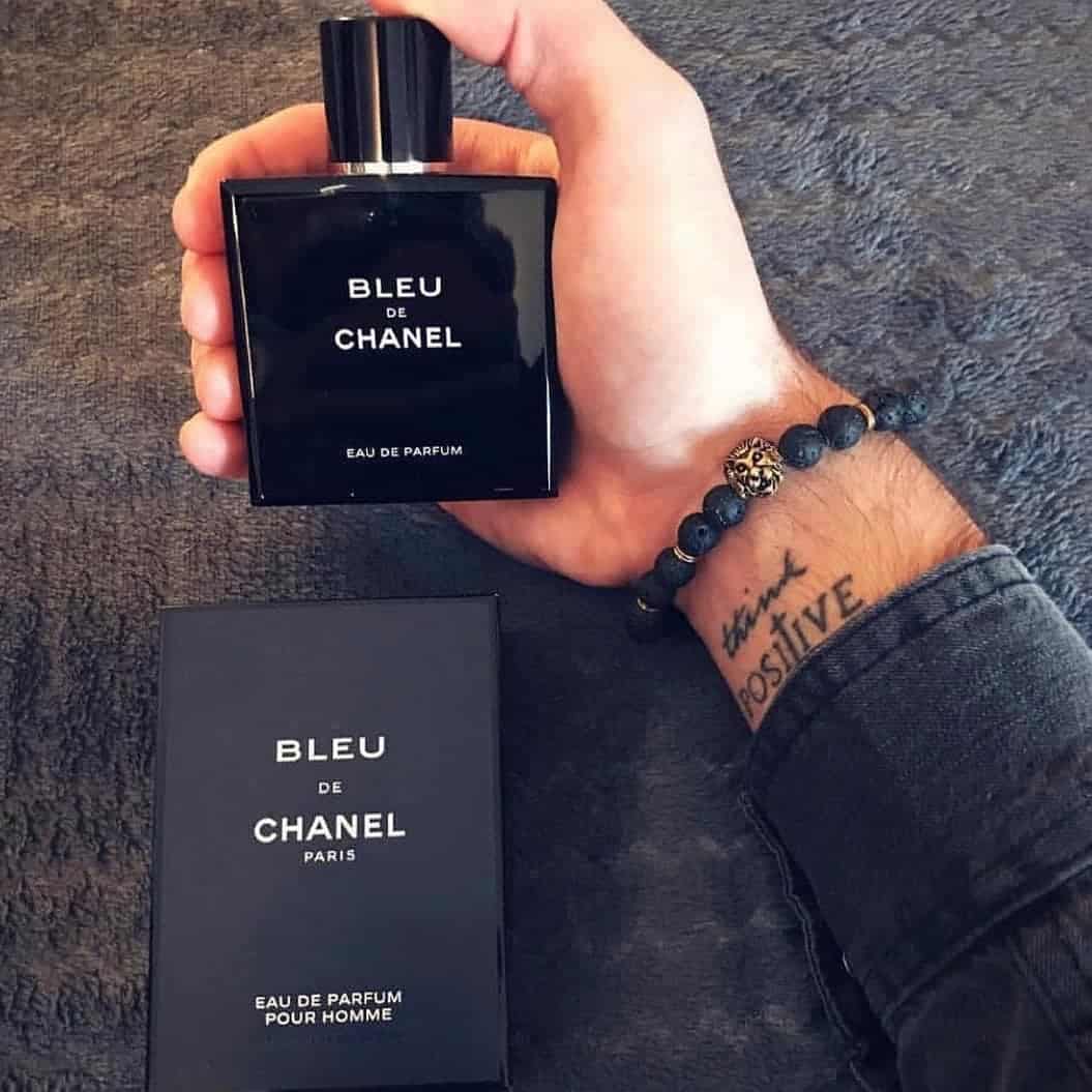 holding a bottle of blue de chanel