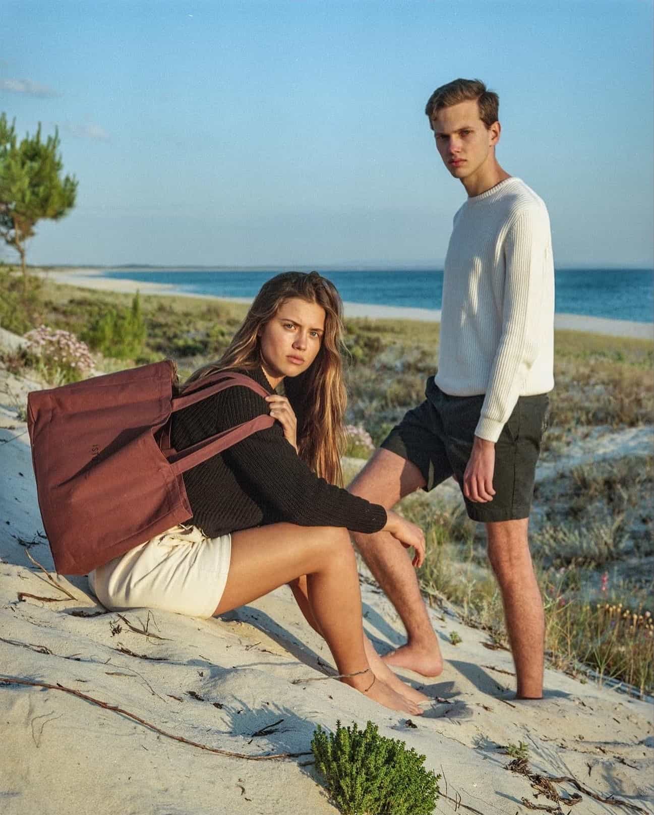 a couple wearing a ribbed sweater at the beach