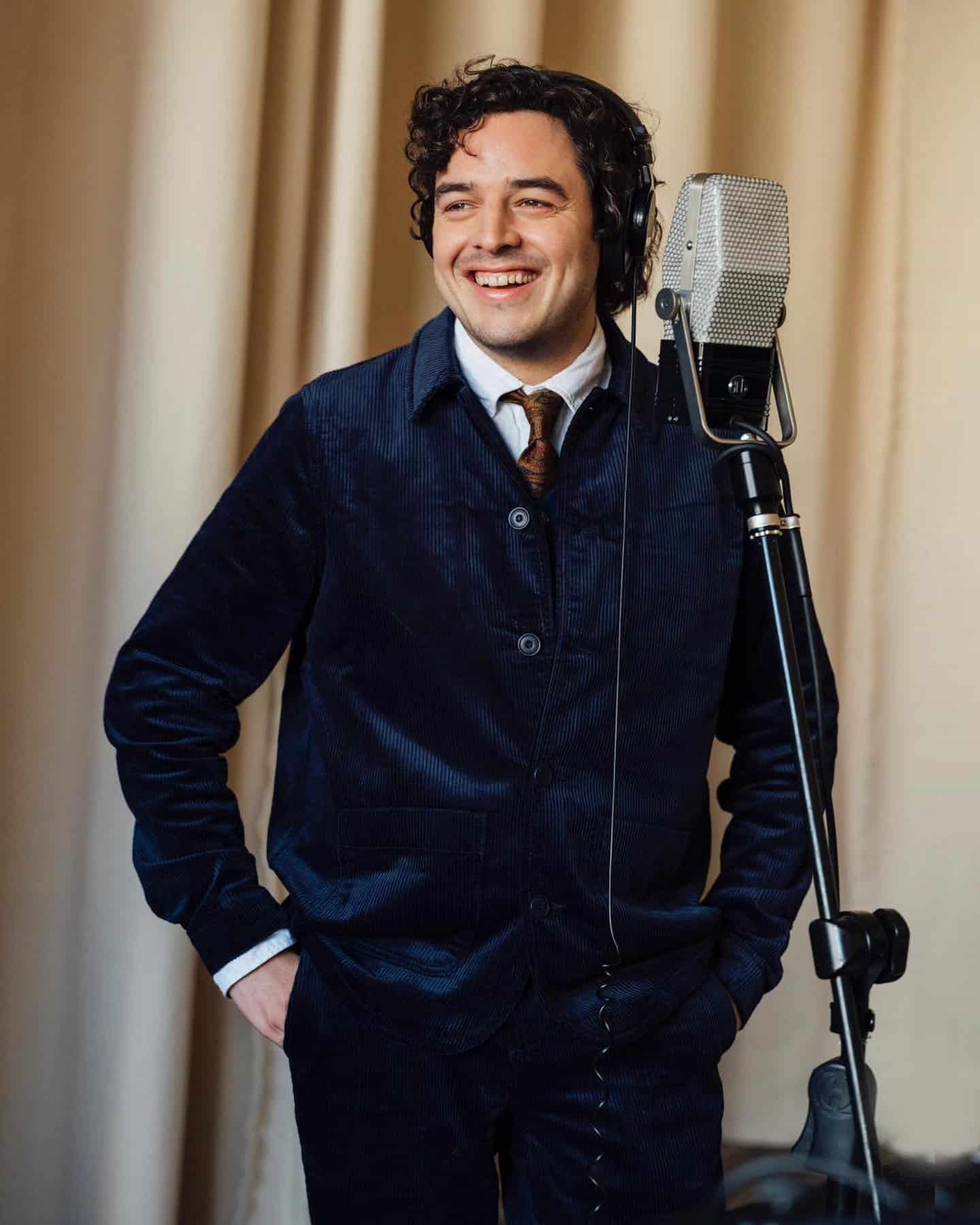 man smiling in-front of a microphone