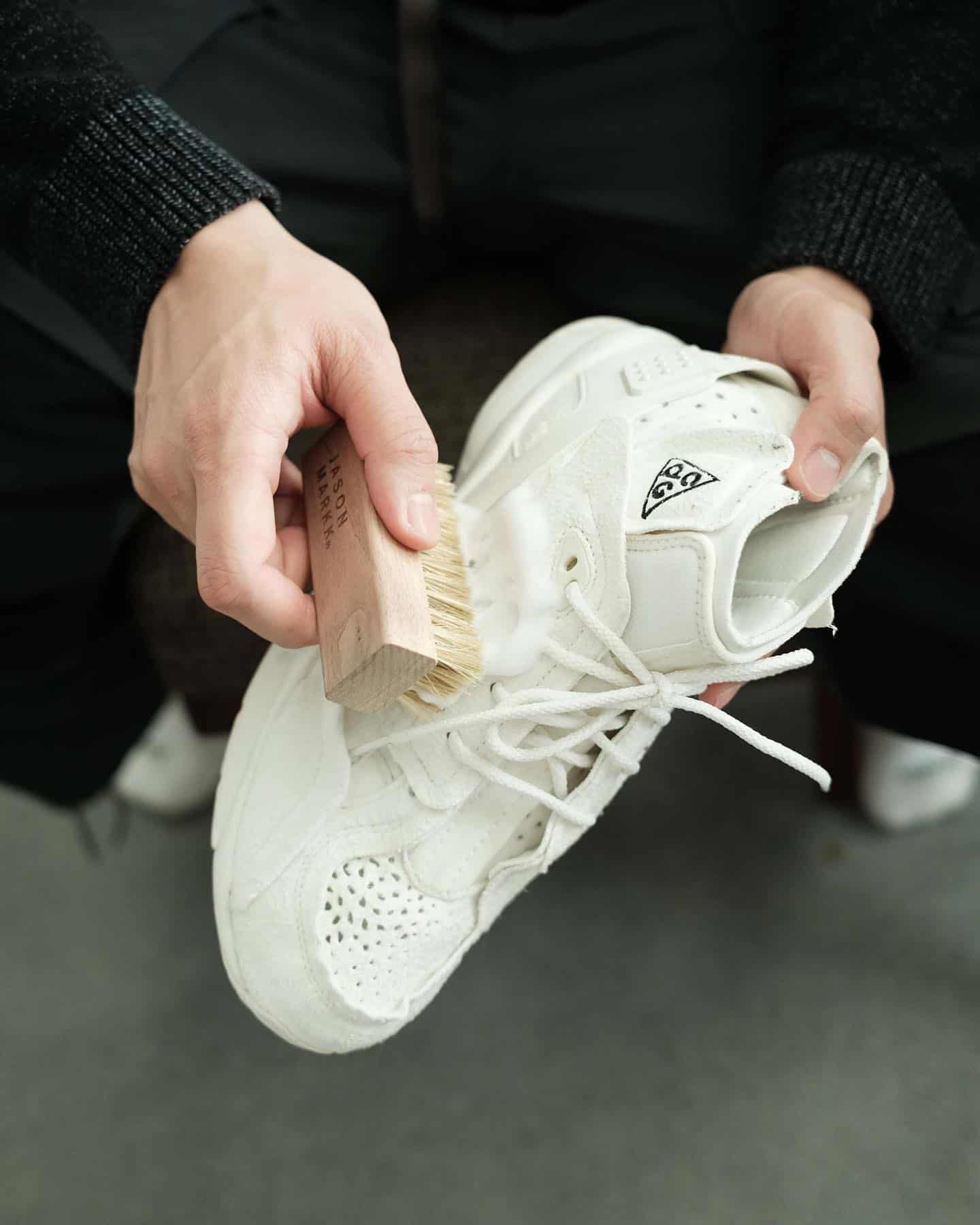 brusing a white sneaker with cleaning solution