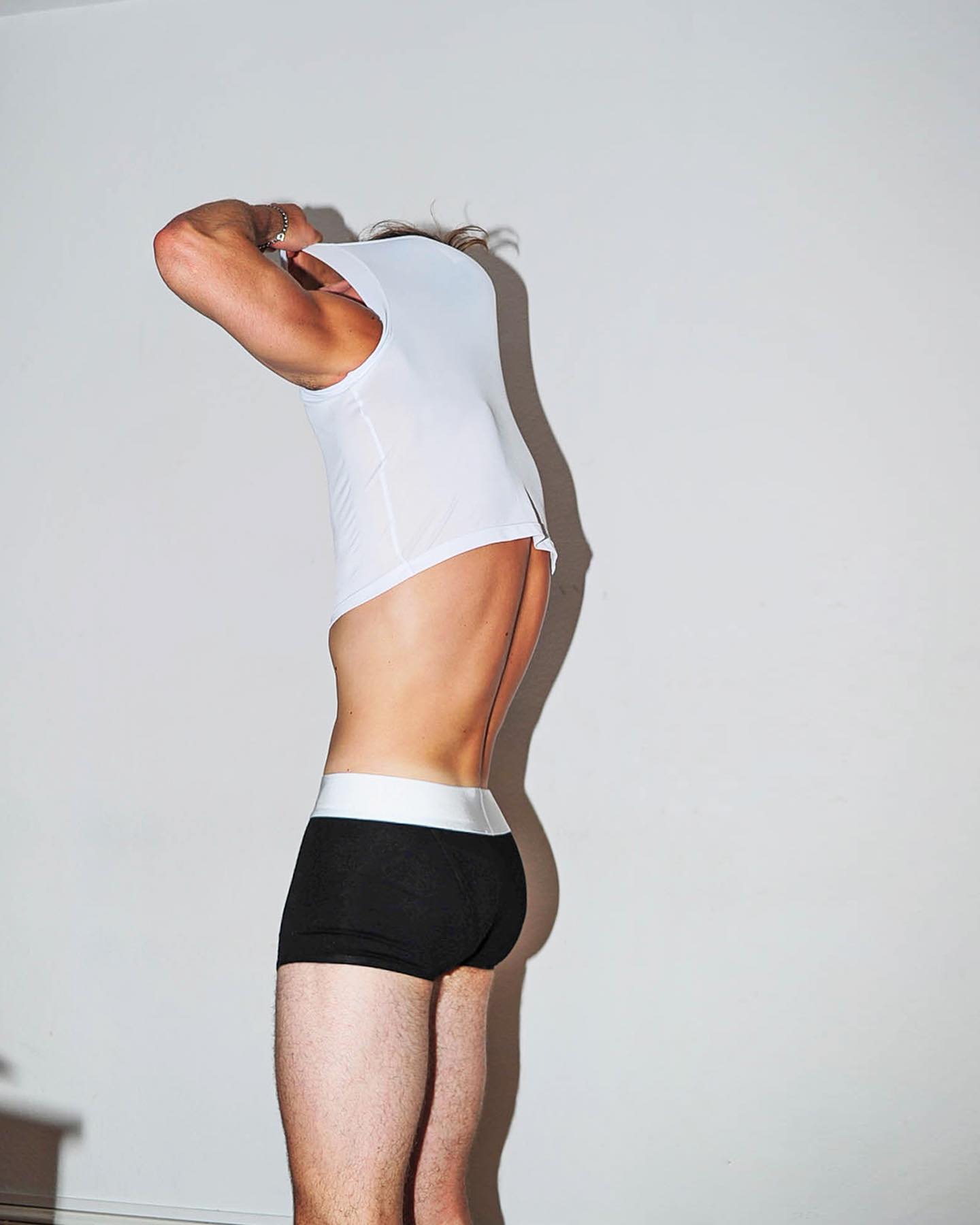 man removing his tank top