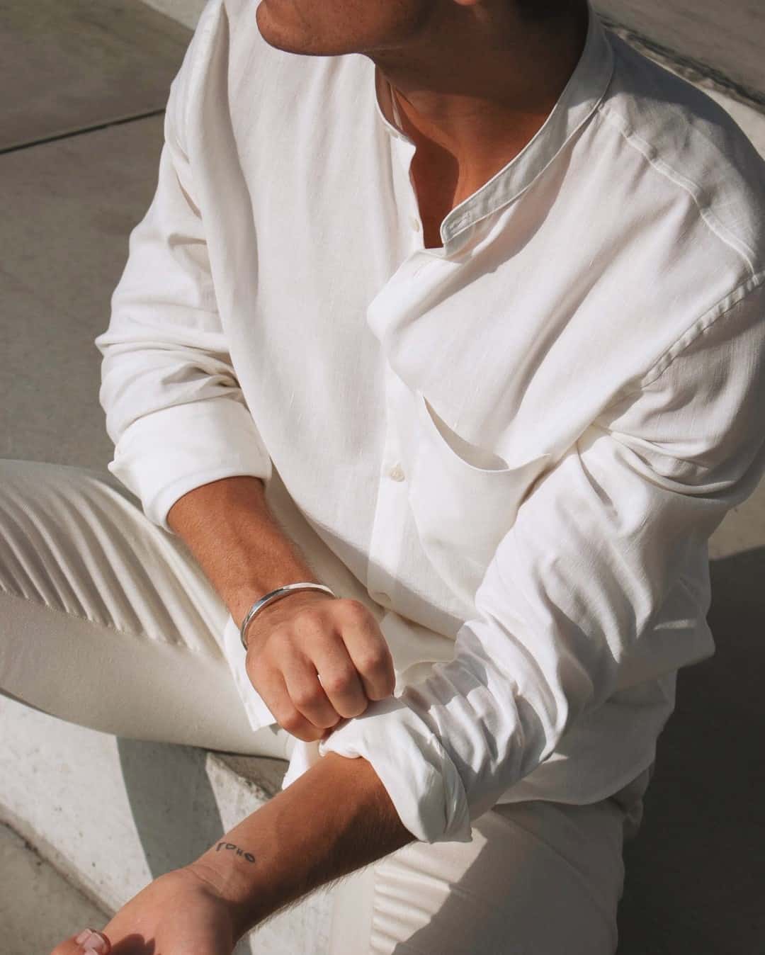 man wearing an off-white colarless shirt