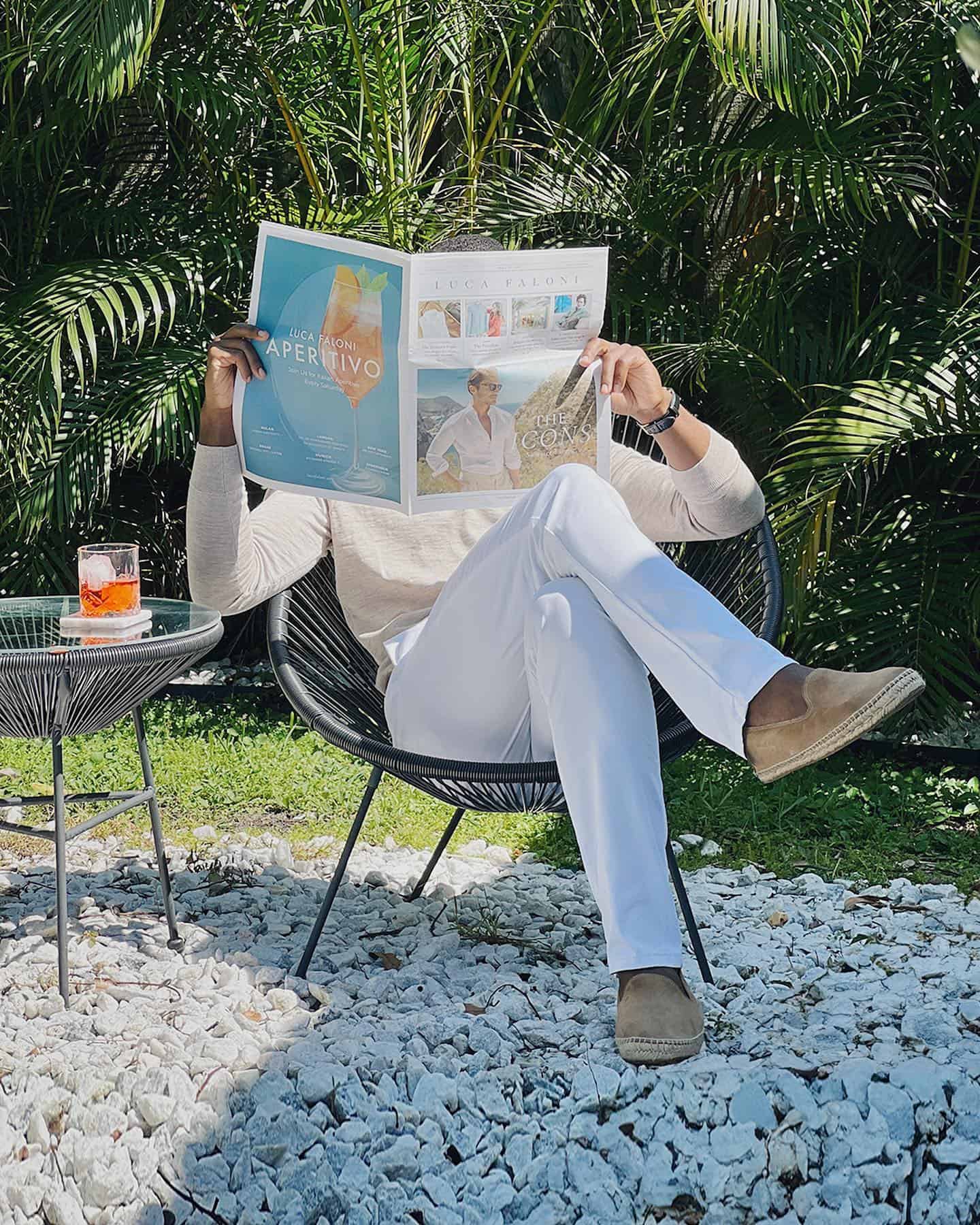 man in a chair reading a paper