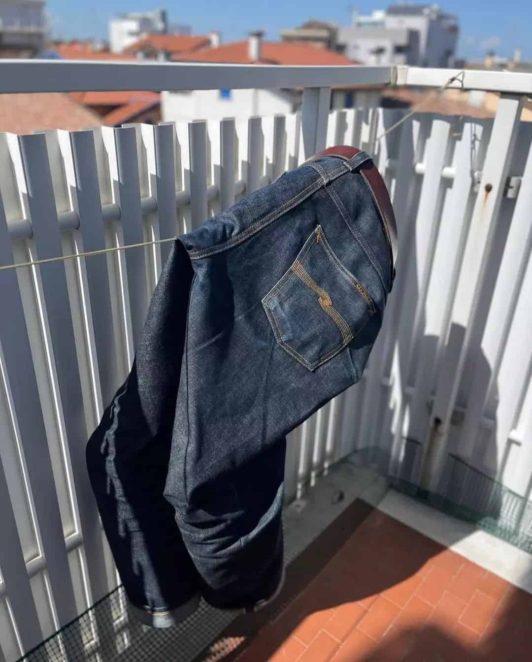 drying a pair of jeans from a balcony