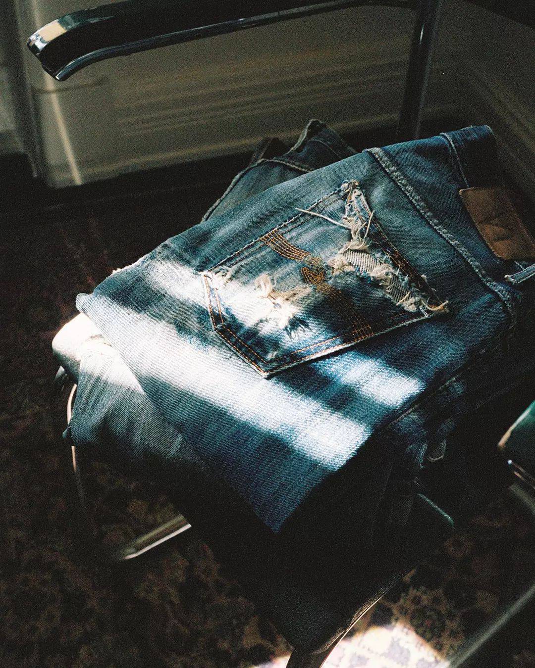 a pile of worn-out jeans on a chair