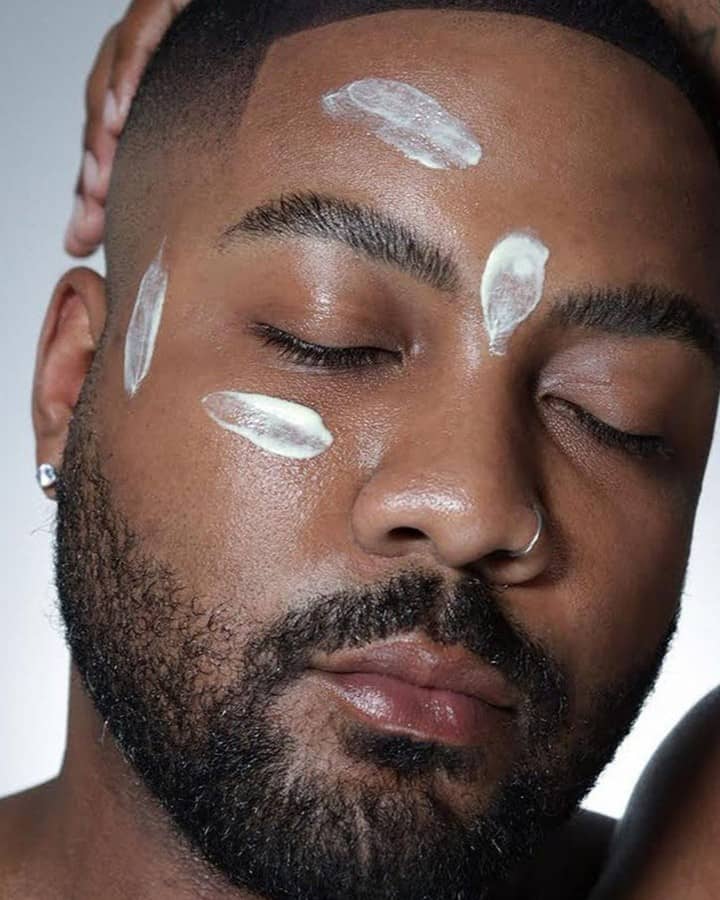 man with dabs of moisturizer on face