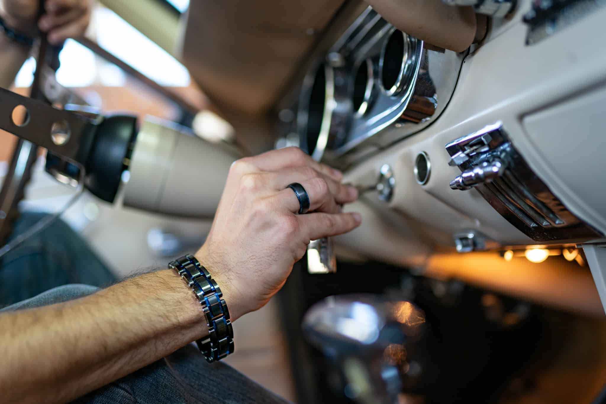 man inserting a key to a classic car key hole