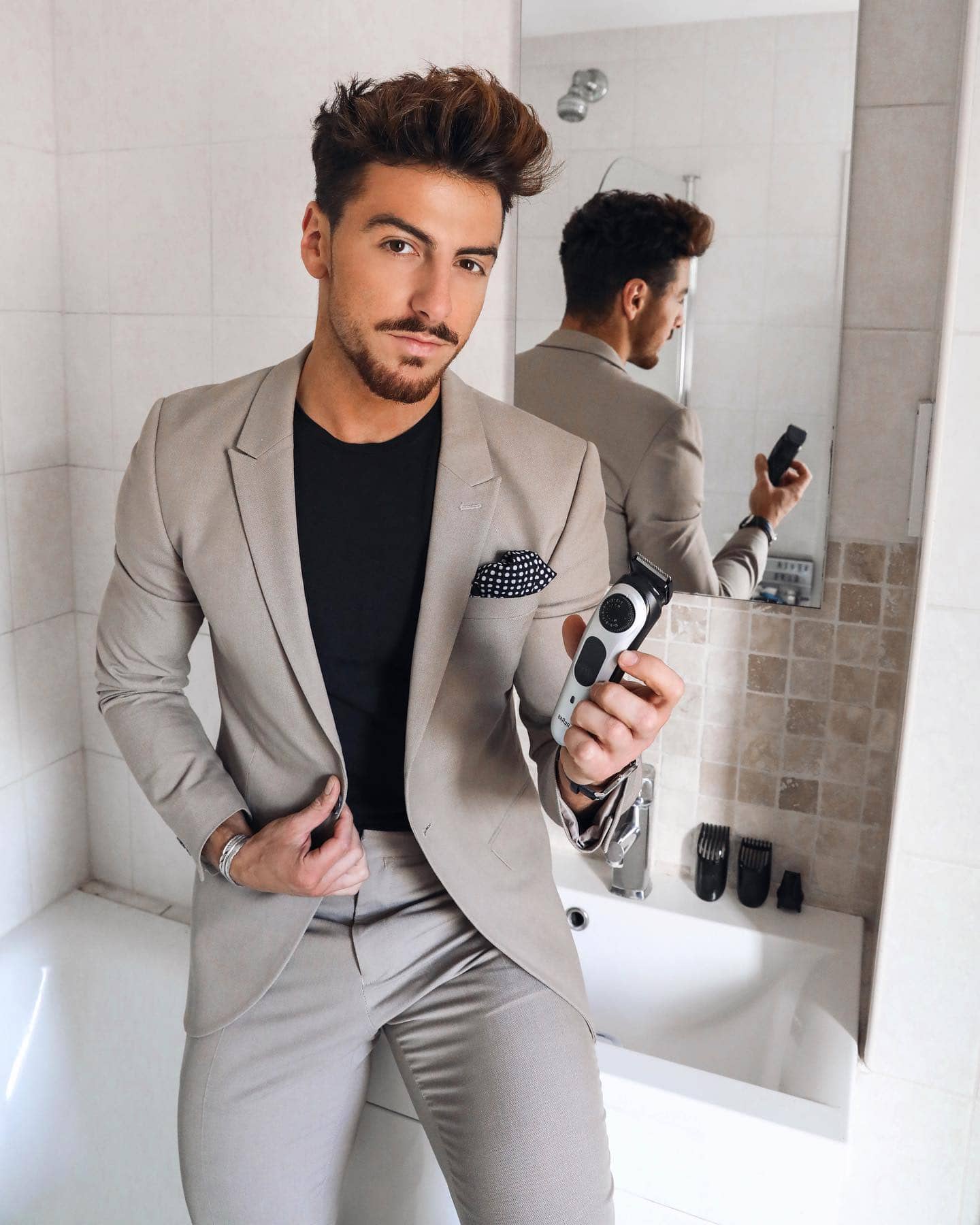 man in suit holding an adjustable beard trimmer by braun
