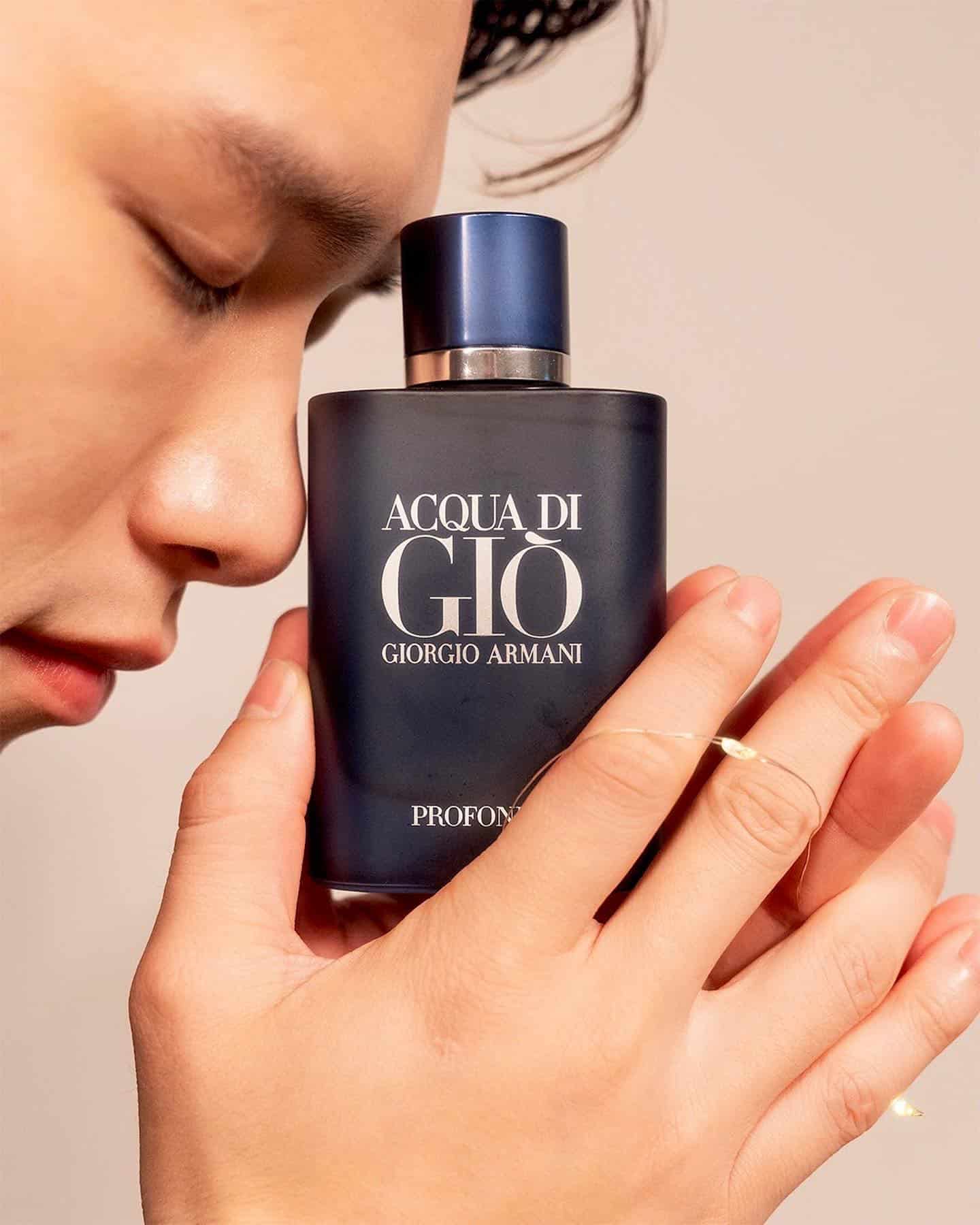 man holding a bottle of acqua di gio profomo with both hands