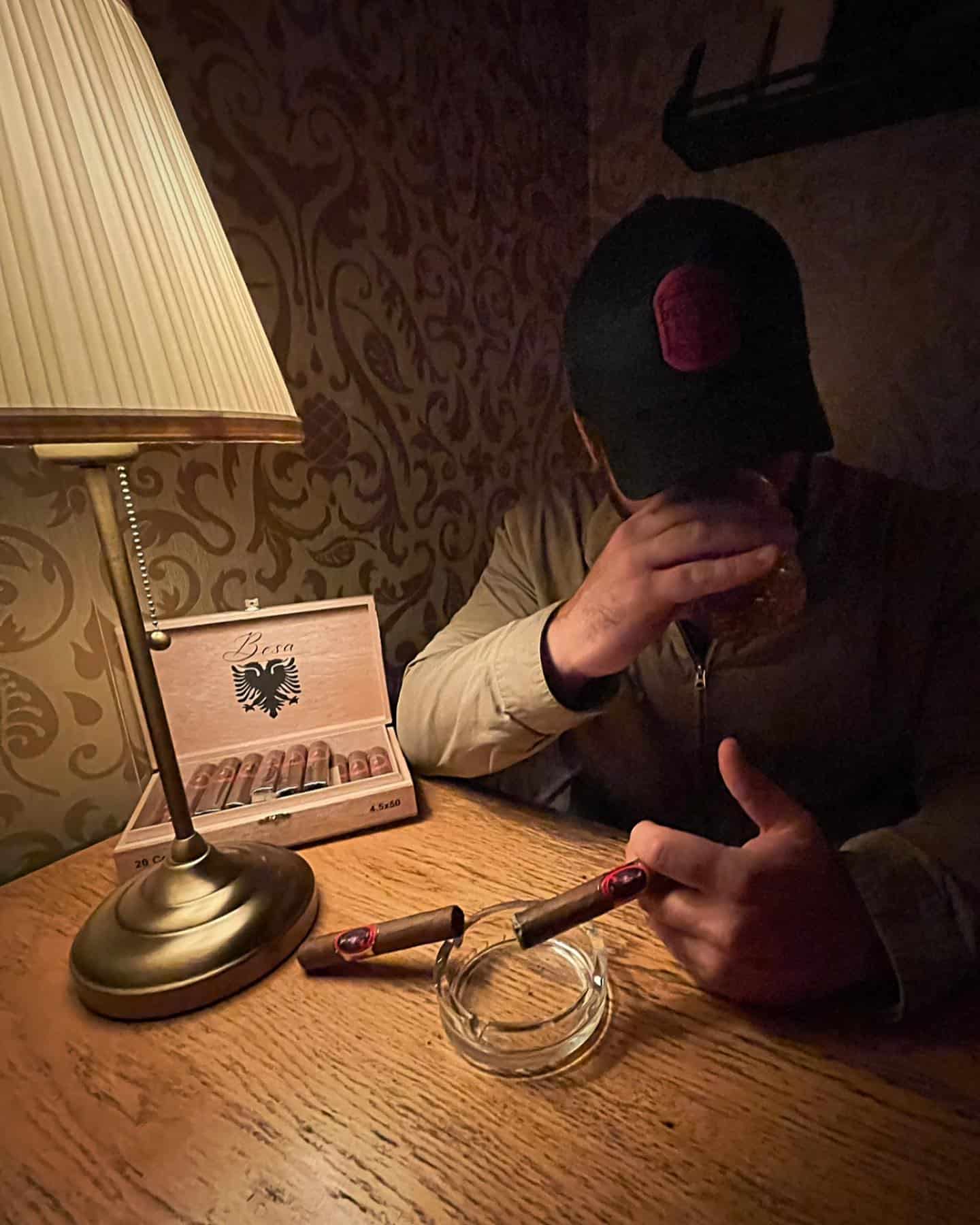 man having a drink and a cigar