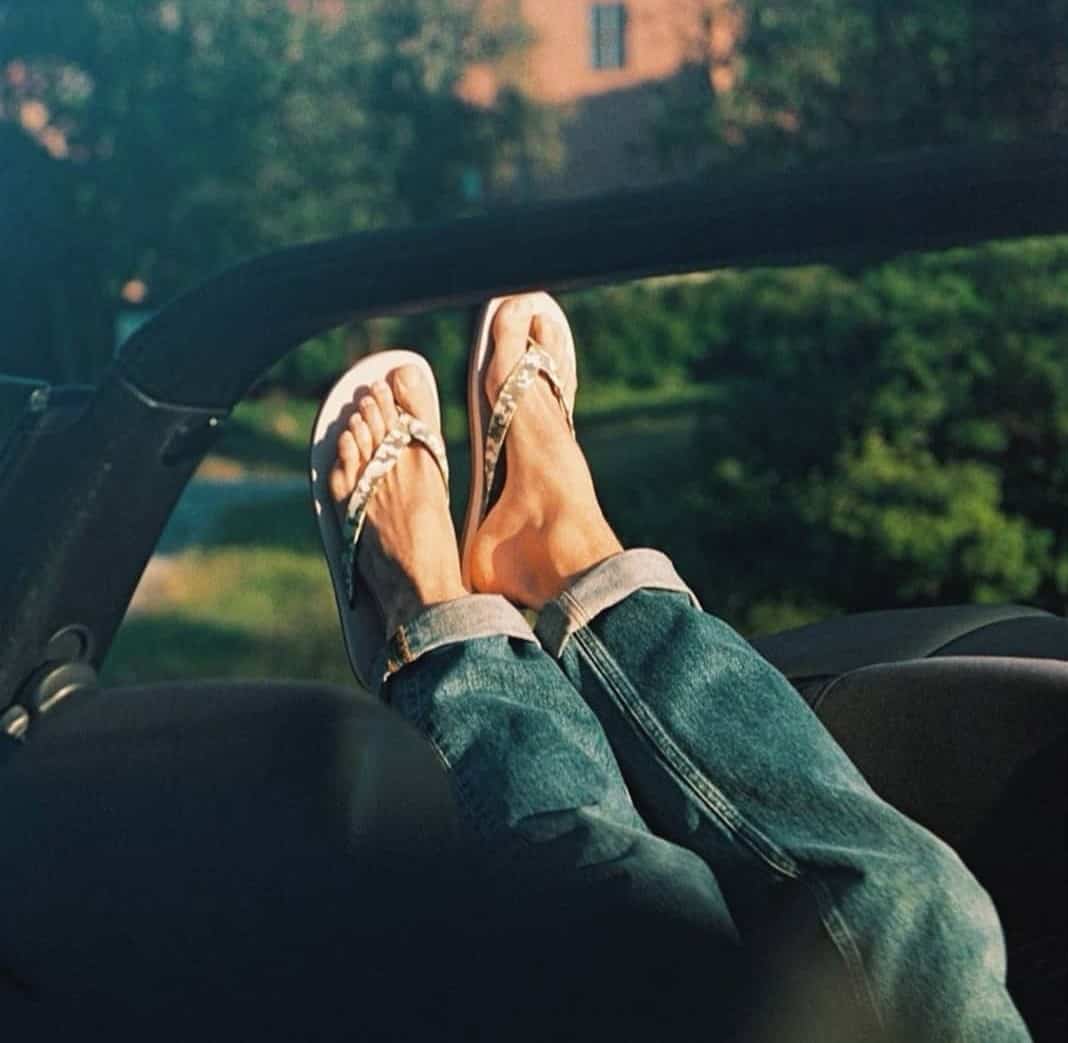 leg pointing upwards from a convertible car