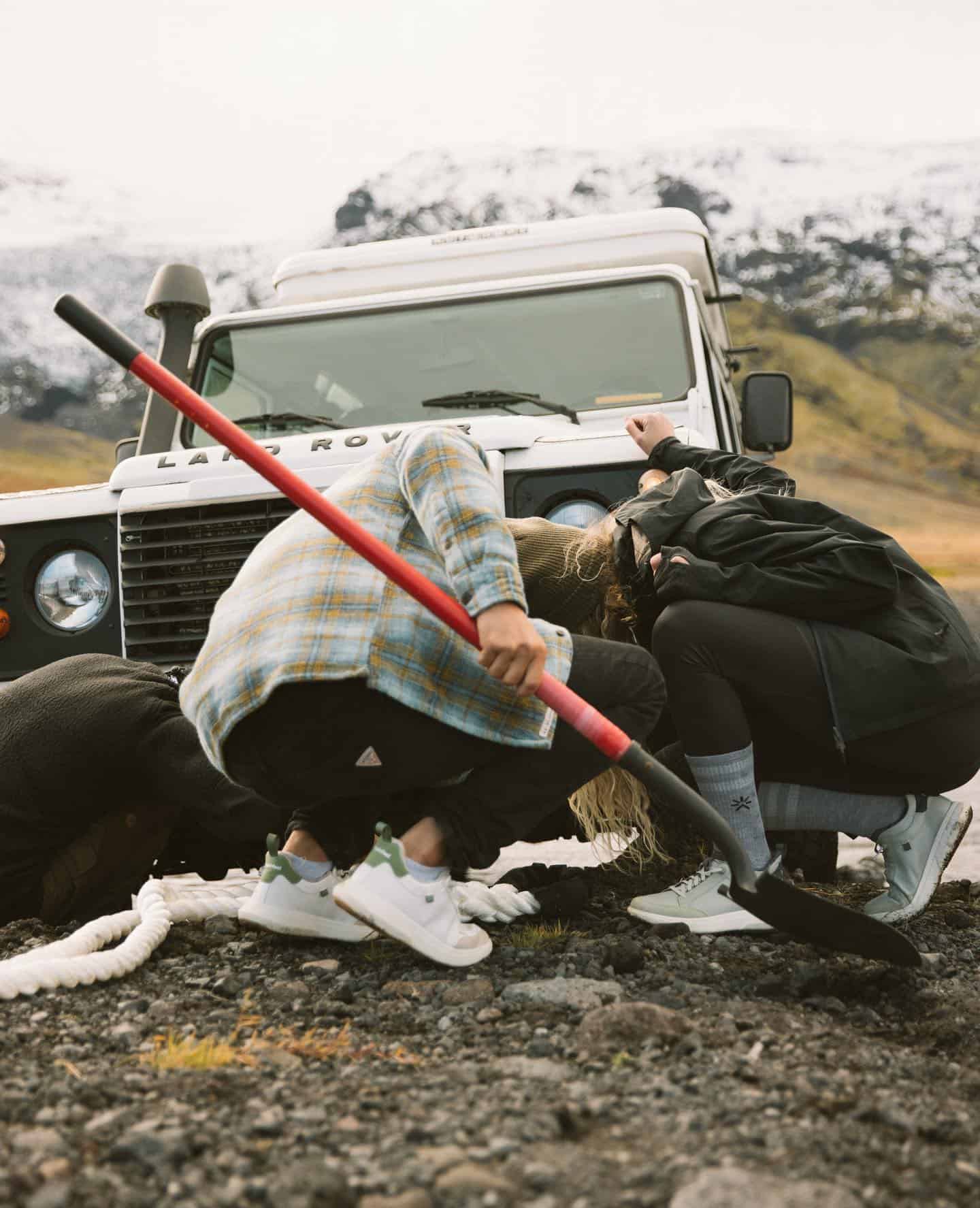 couples checking a stuck car by the river side