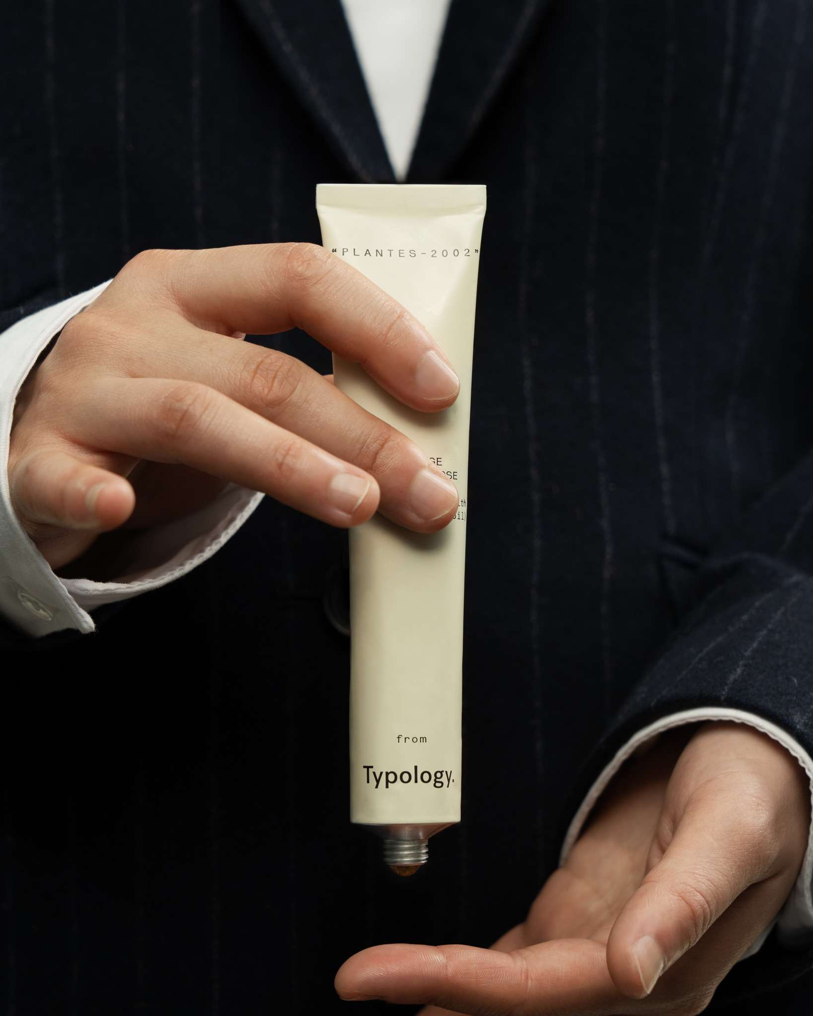 holding a tube of body scrub by typology