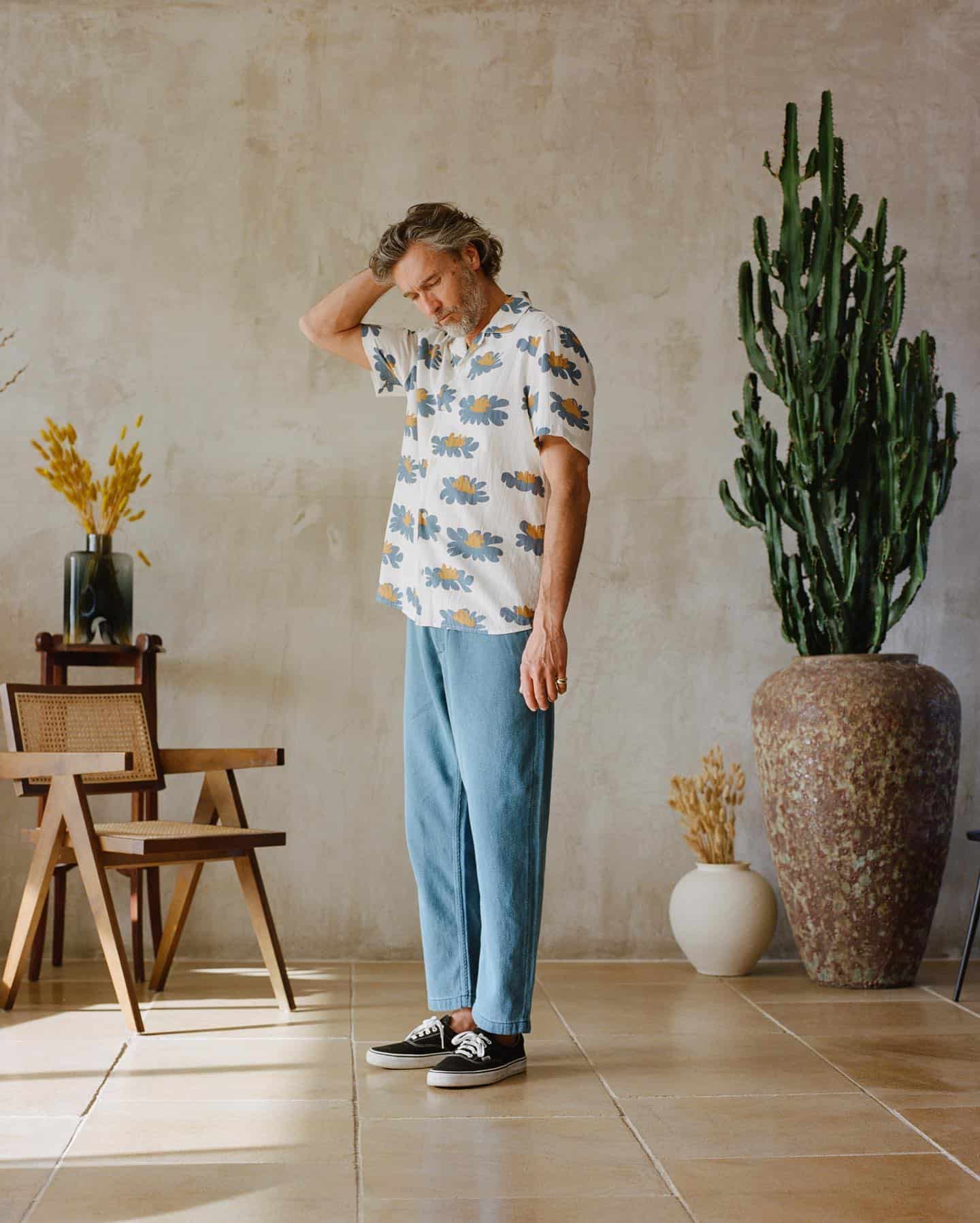 man in printed shirt scratching his head