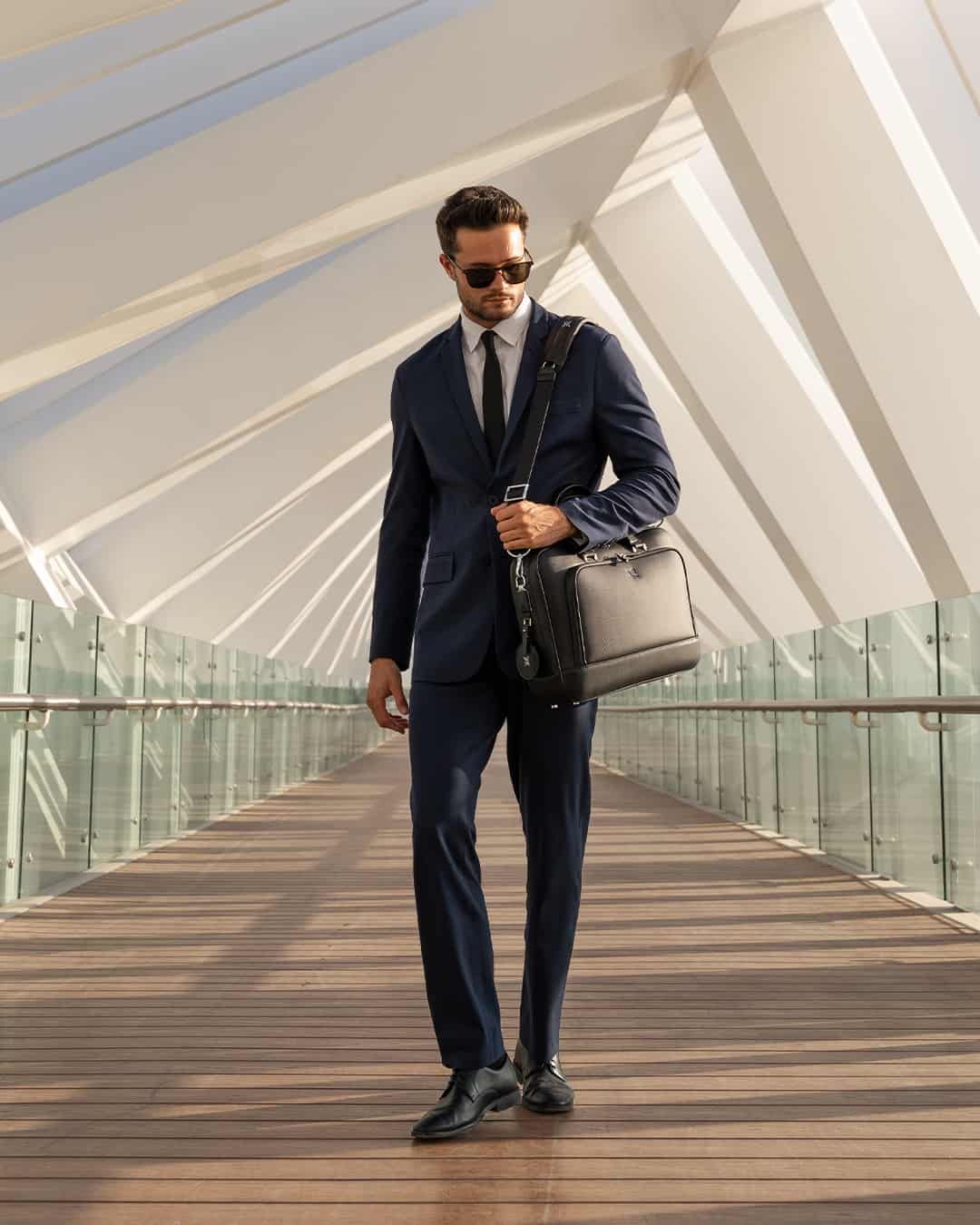 man in a navy suit carrying a briefcase