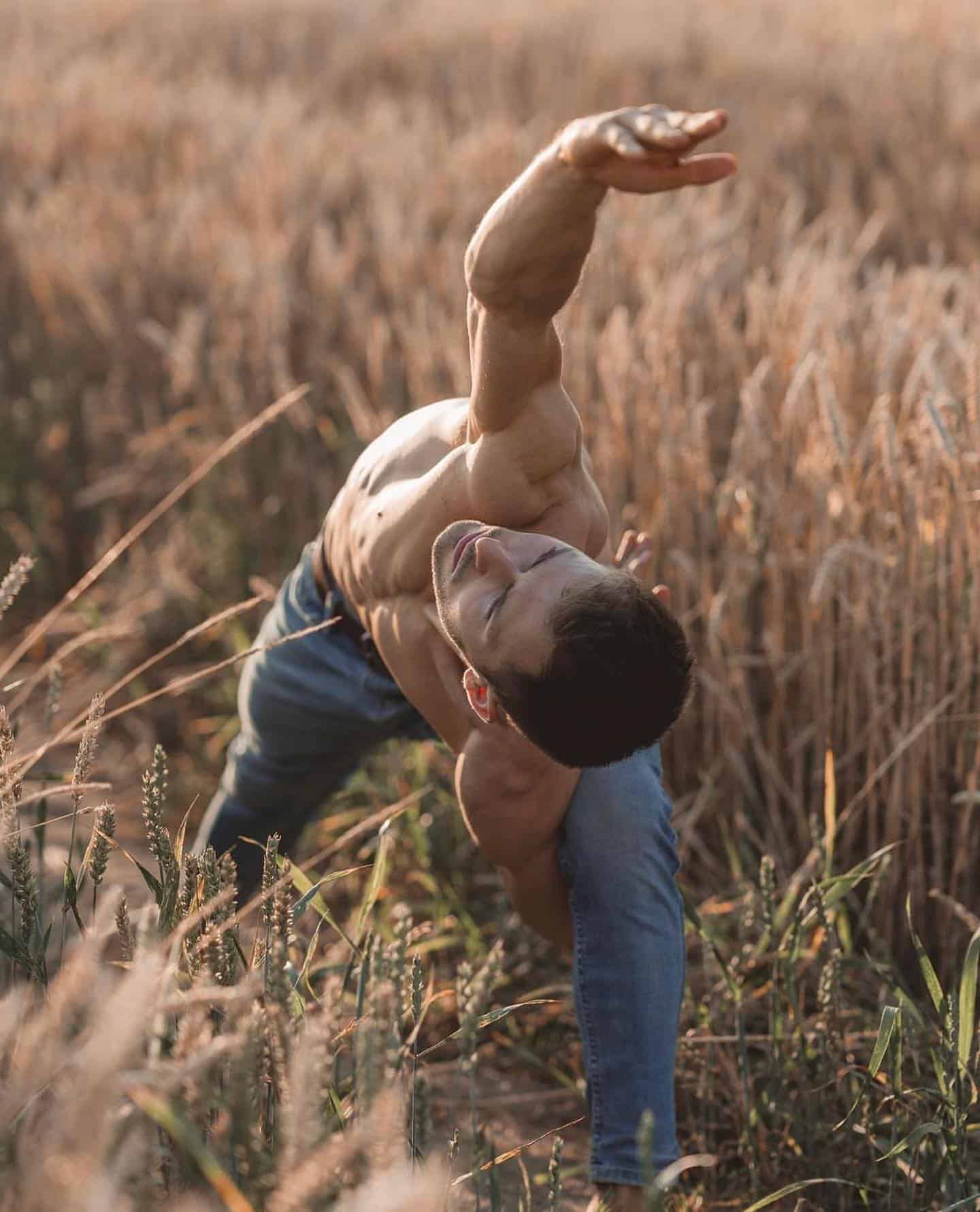 man doing yoga in a field