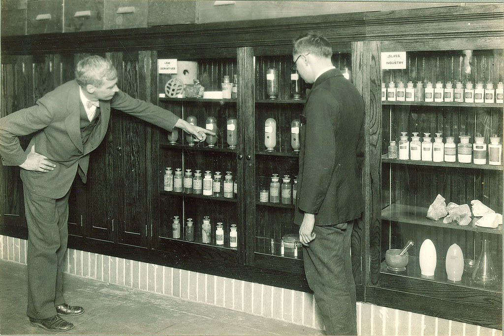 Men looking at a cabinet of chemistry compounds, The University of Iowa, 1930s" by The University of Iowa Libraries