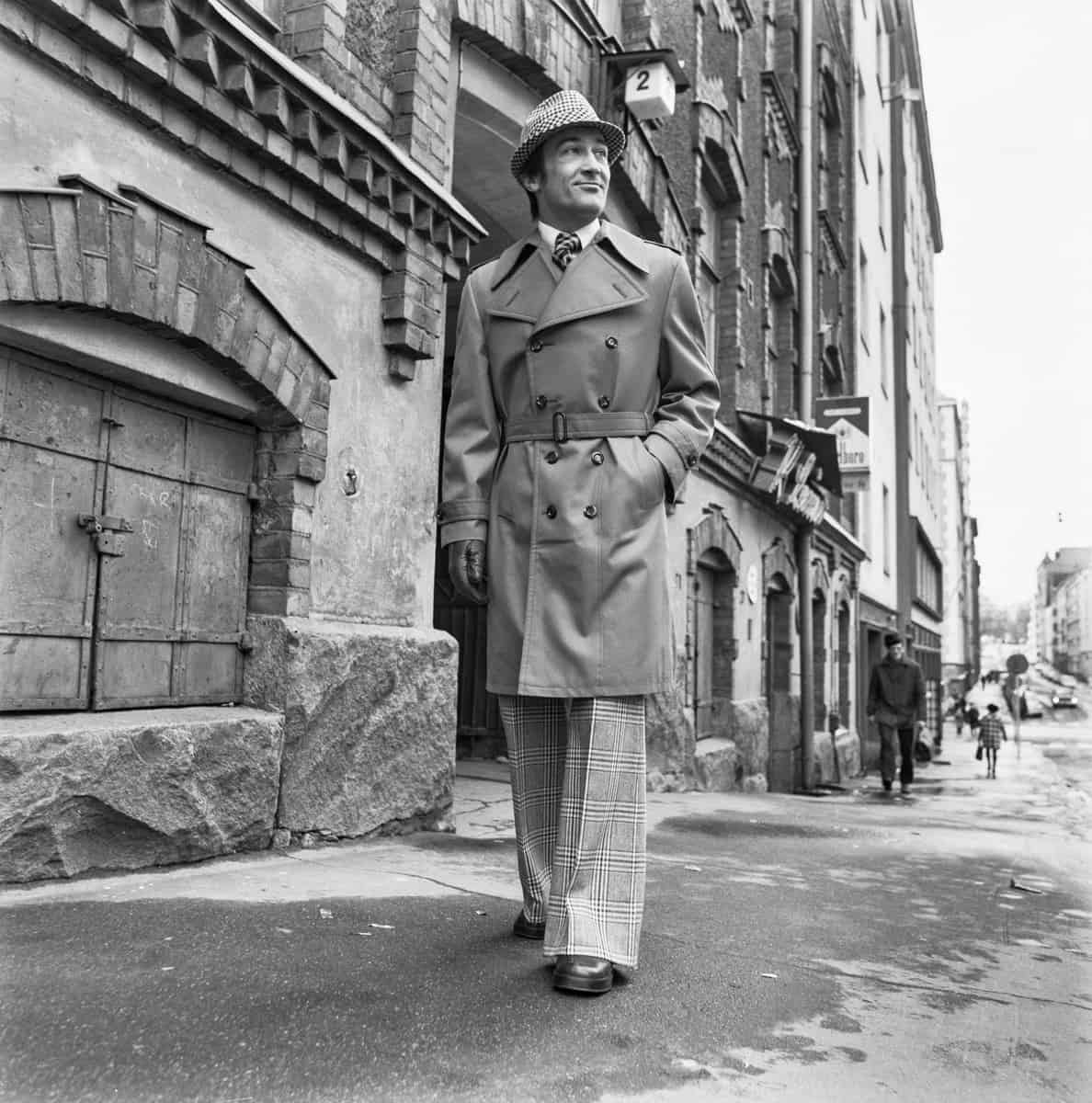 Man in 1970s wearing a double breasted coat walking