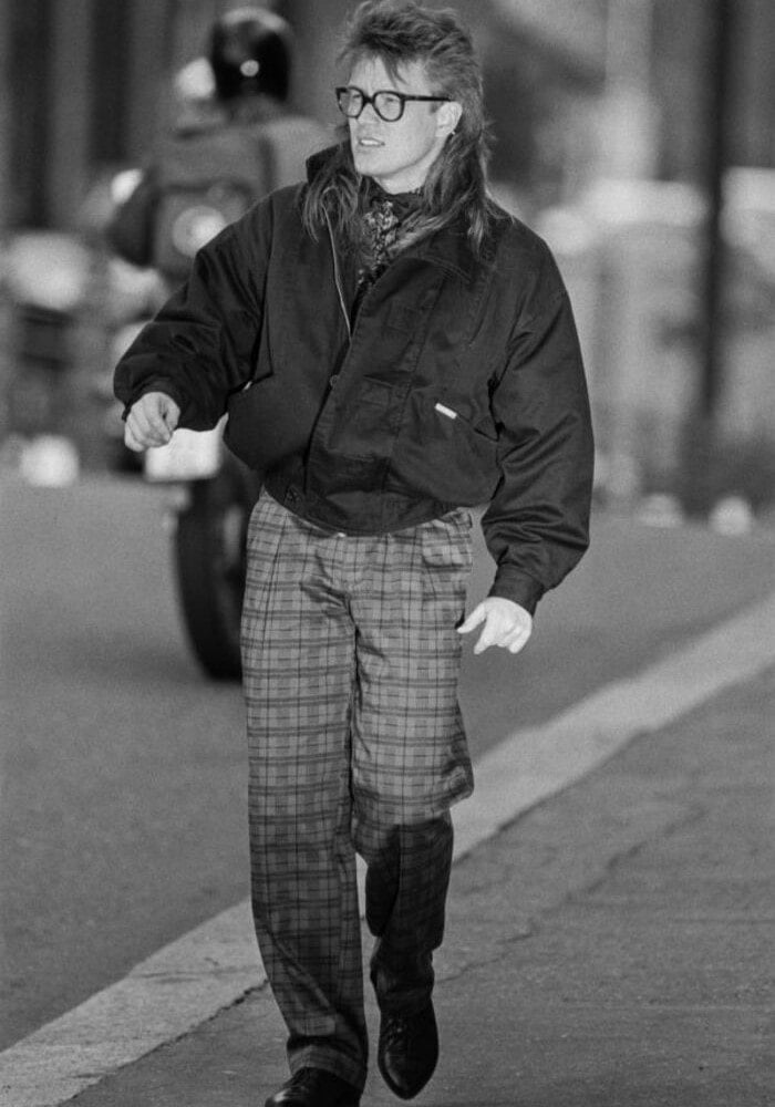 A man in 1980s wearing a jacket and checked pants