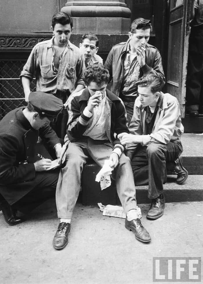 a group of men in 1950s being questioned by the police