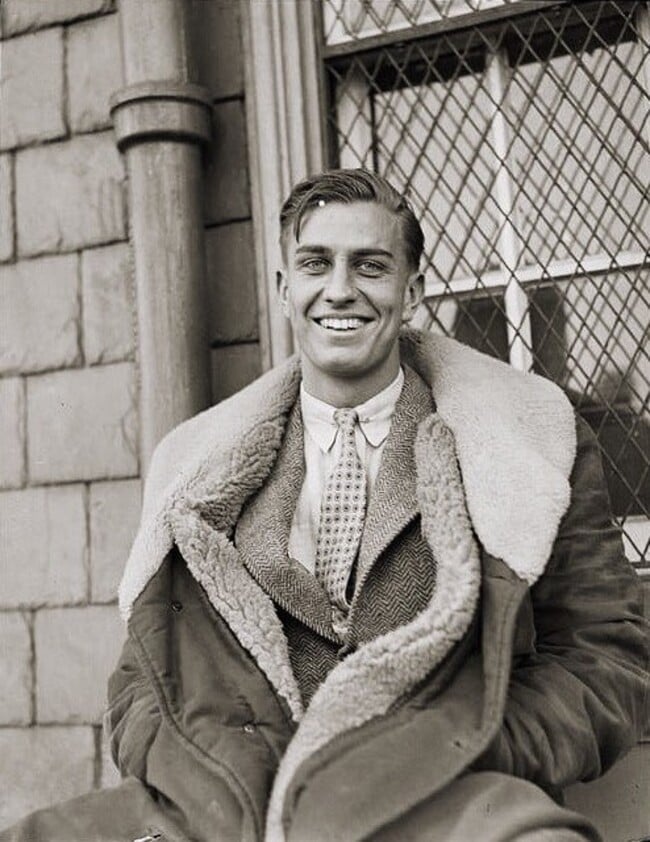 man in 1930s wearing a coat over a suit