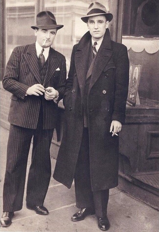 two men in 1930s smoking a cigarette