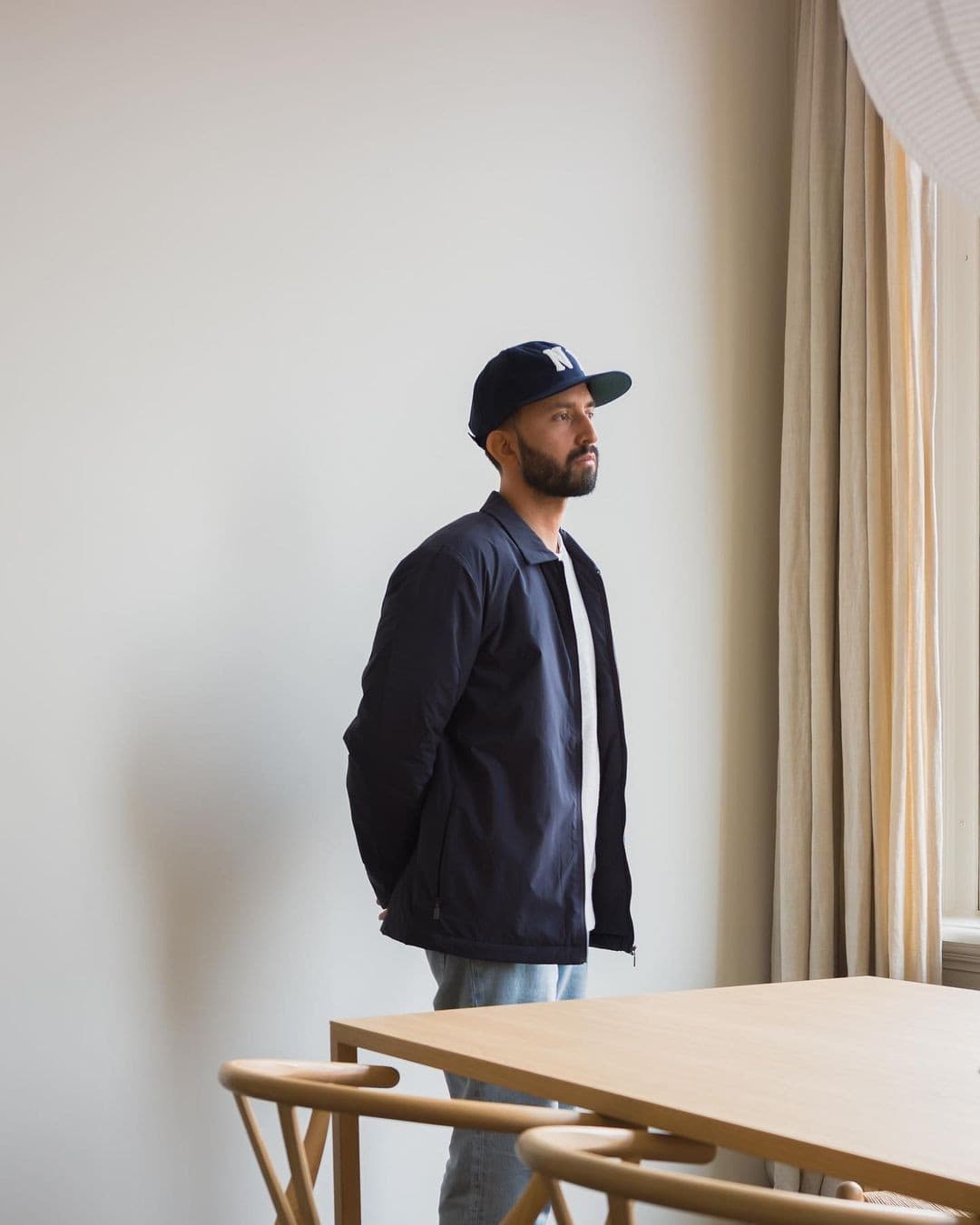 man in a hat wearing the zip jacket by asket