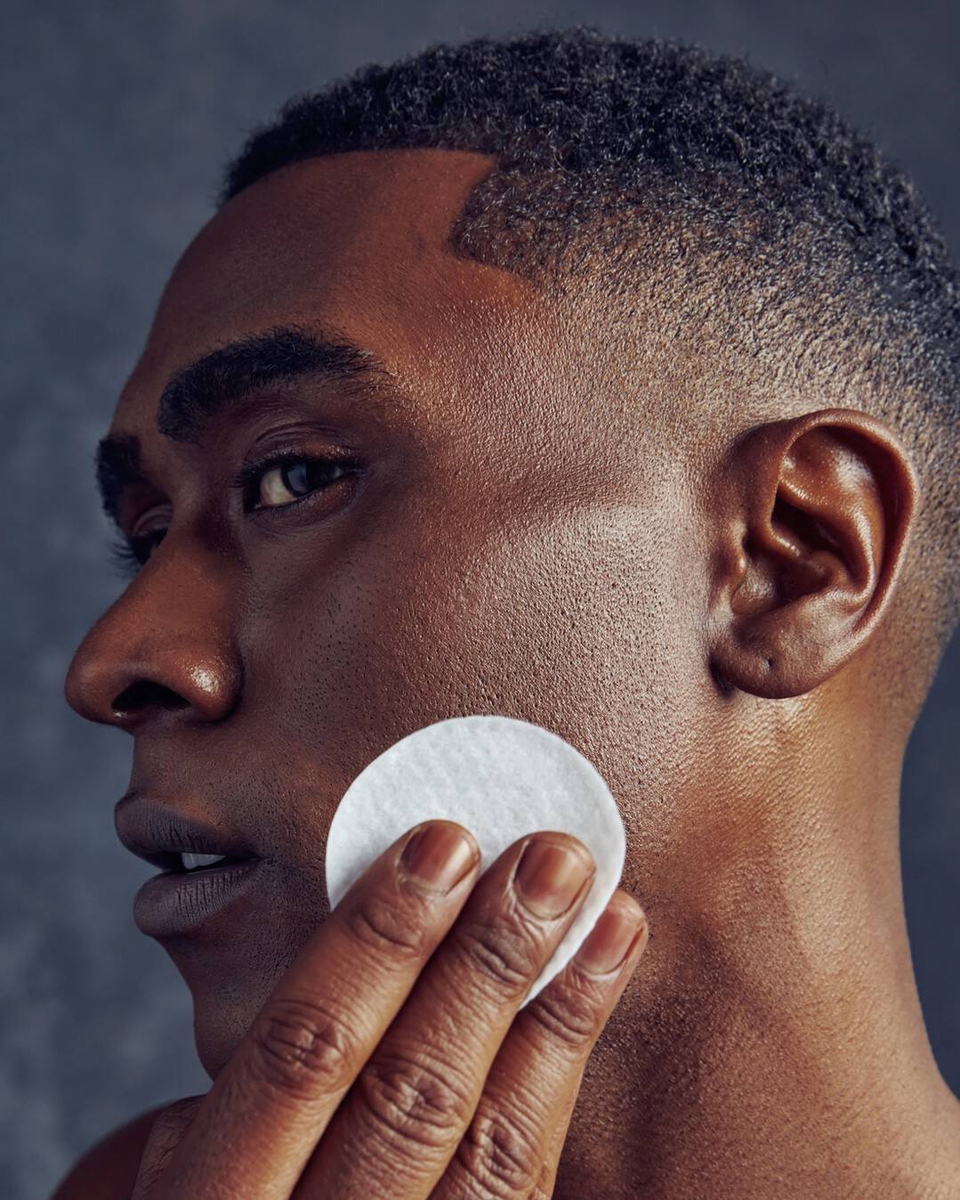 man wiping face with an exfoliating pad by bevel
