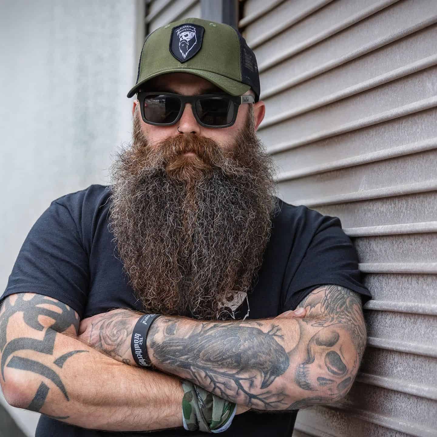man with long beard wearing a trucker hat and sunglasses