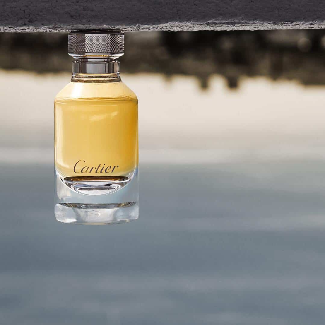 an upside down bottle of lenvol de cartier cologne