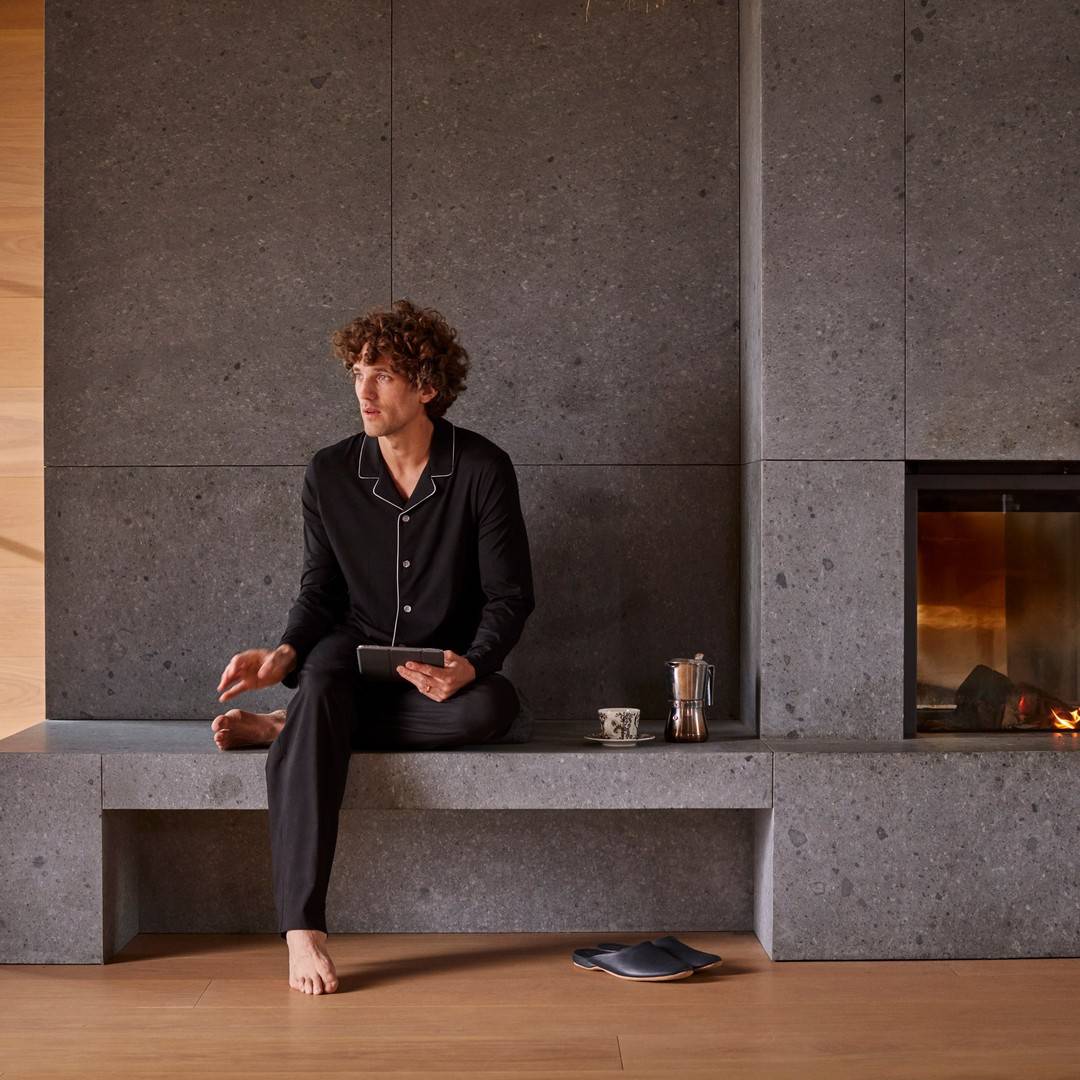 man sitting by the fire furnace holding an ipad