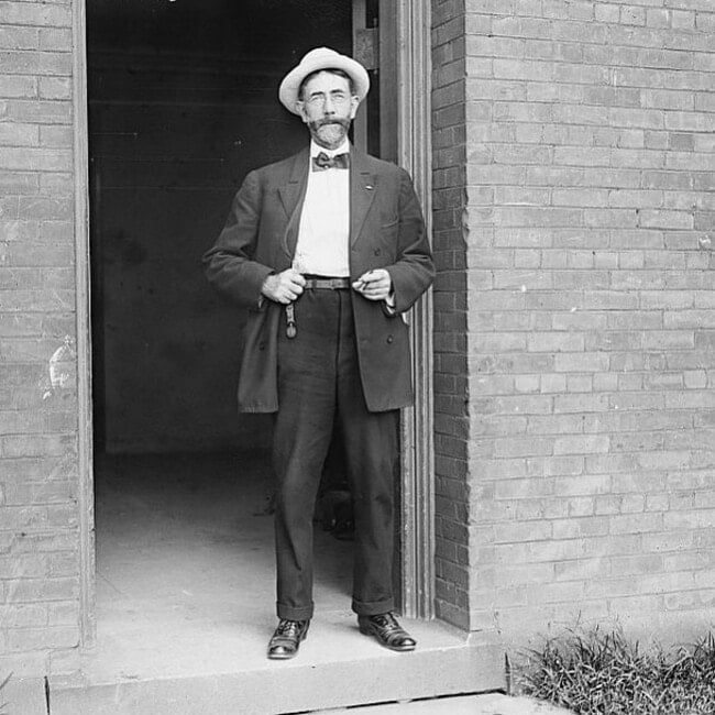 man in 1910 wearing a suit with bow tie
