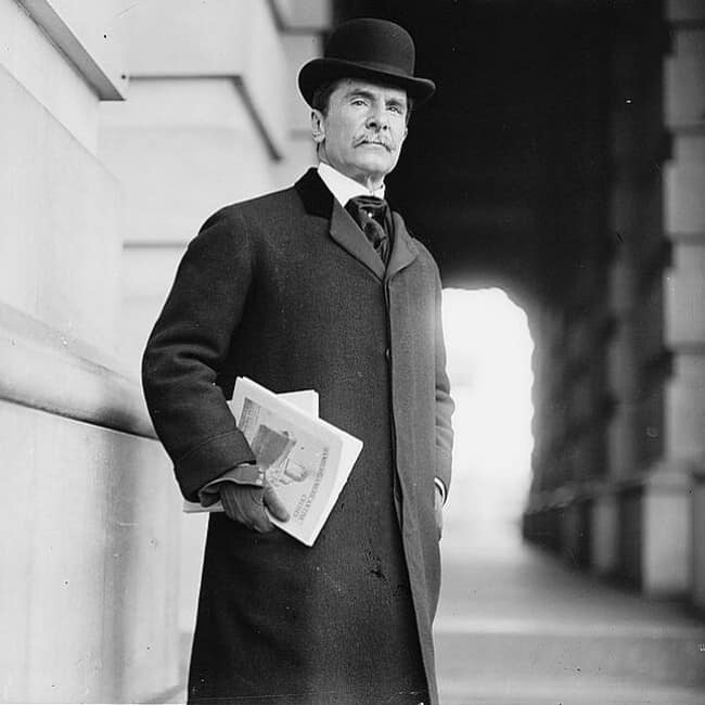 man in 1910 wearing a long coat