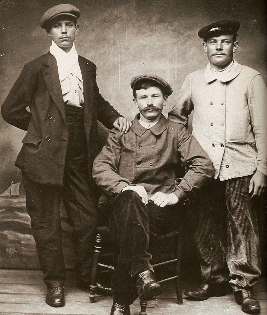 three men in 1910 wearing vintage workwear
