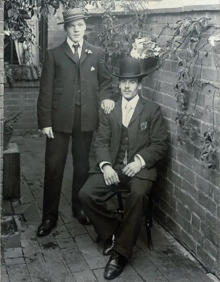 two men in a vintage suit and hat
