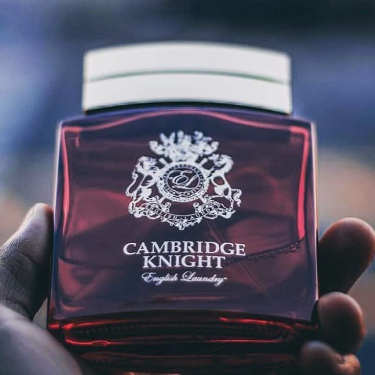 holding a bottle of cambridge knight cologne by english laundry
