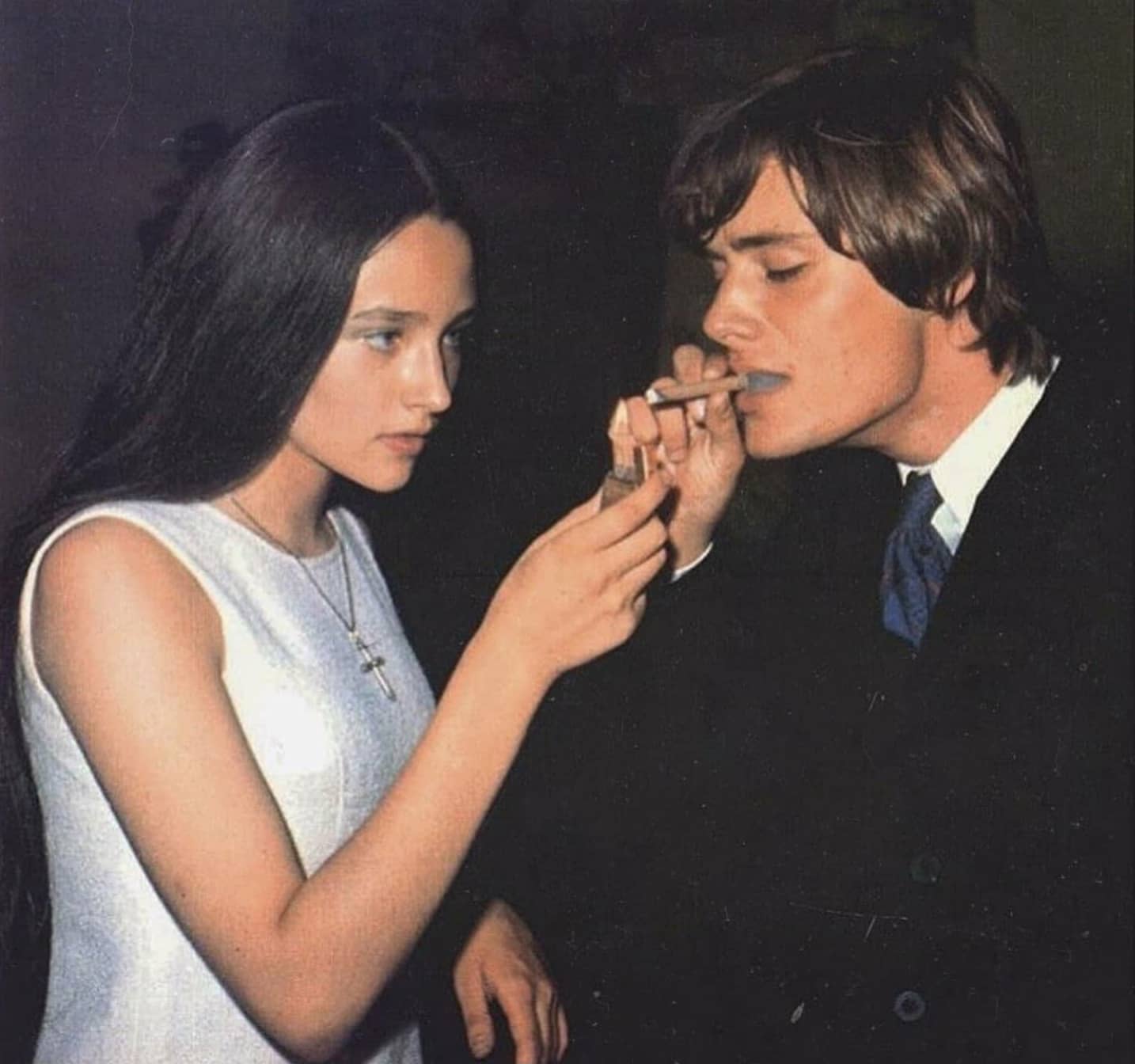 a woman lighting a mans cigar