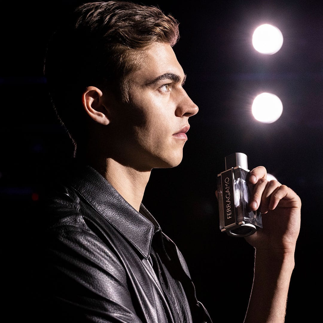 man holding a bottle of ferragamo intense leather cologne