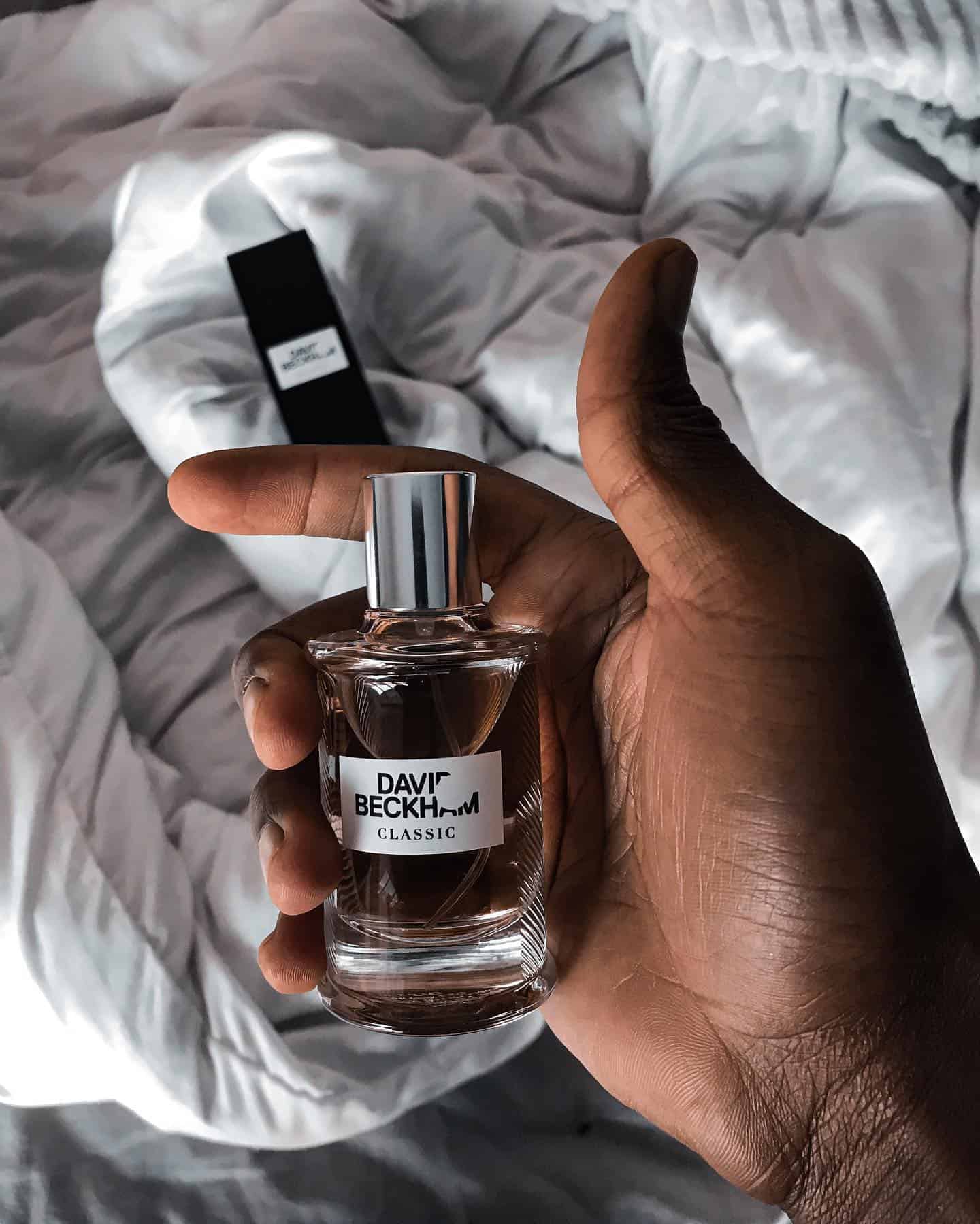 holding a bottle of david beckham classic cologne