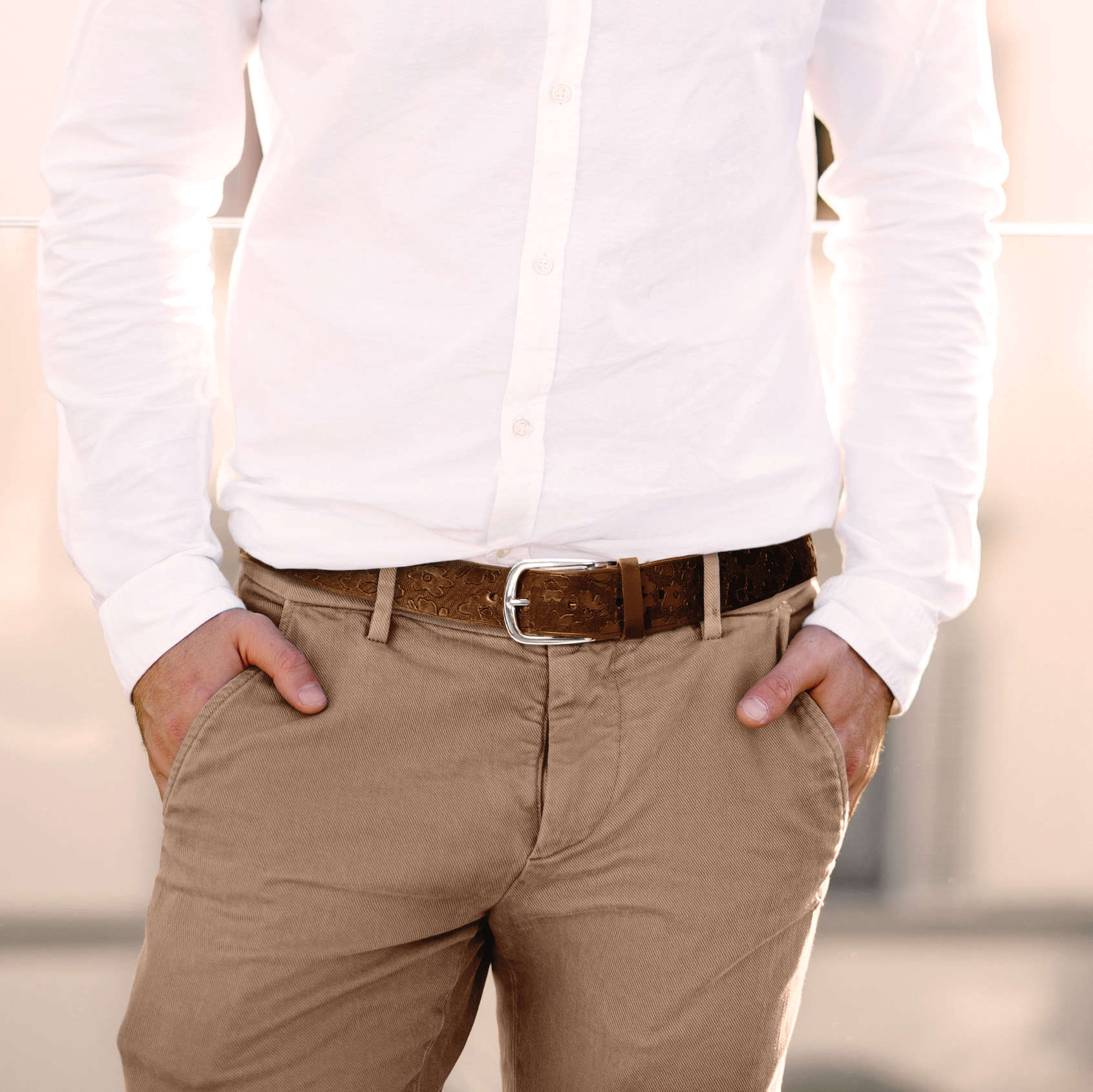 man wearing a leather belt with floral pattern