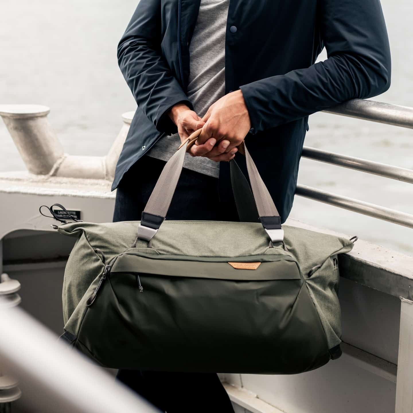 man carrying a duffel bag by peak design