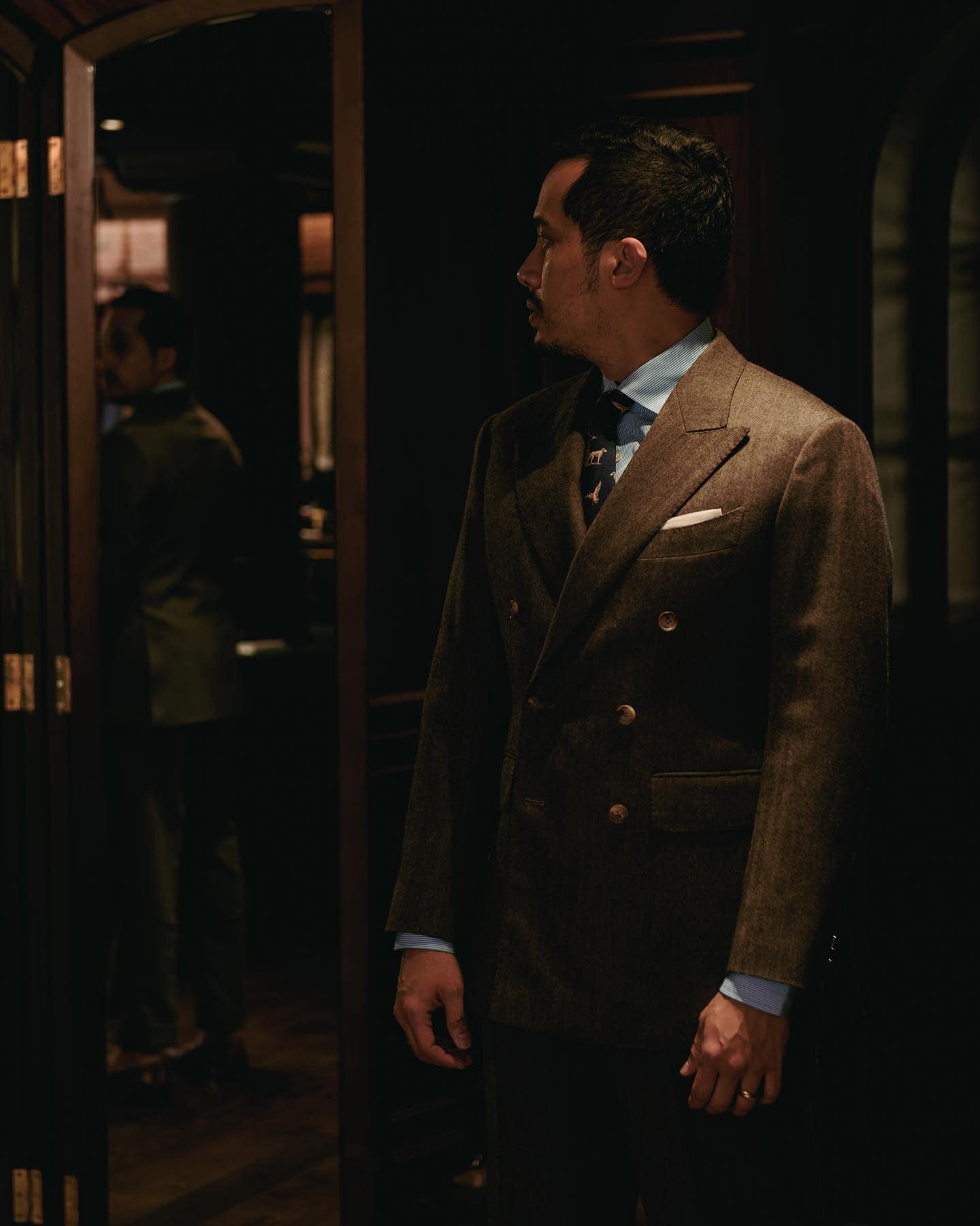 man checking his vintage style double-breasted suit in the mirror