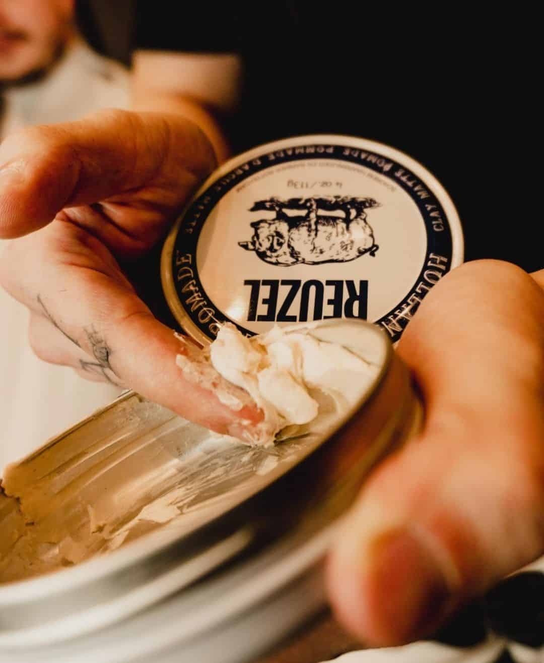 scooping out a clay matte pomade by reuzel