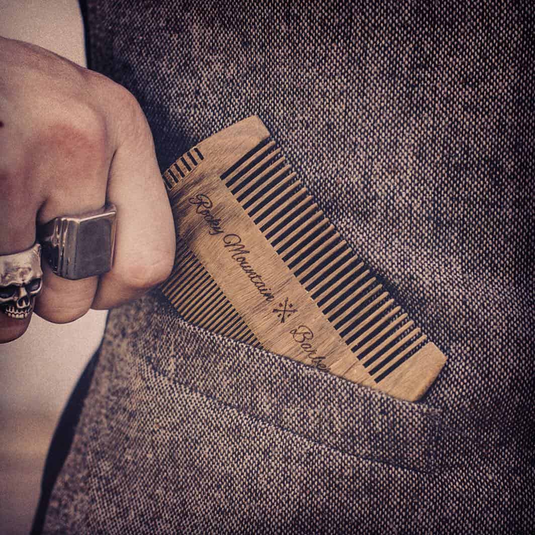 man inserting a hatchet comb in front pocket of a jacket