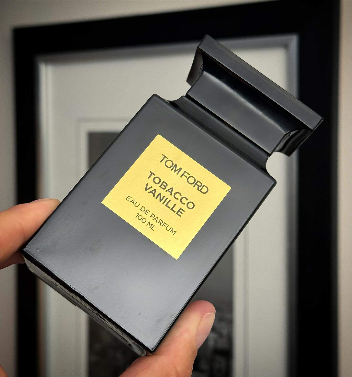 holding a bottle of tom ford tobacco vanille