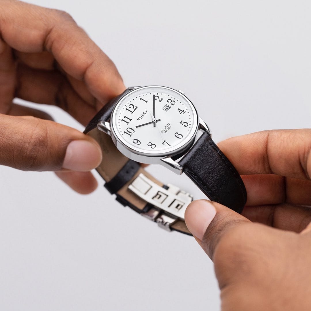 holding a timex watch with leather strap