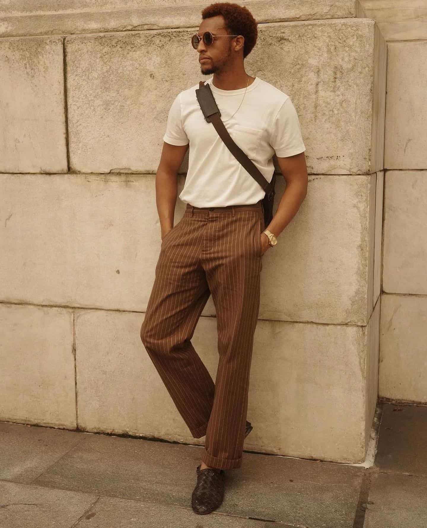 man in white shirt leaning on a wall